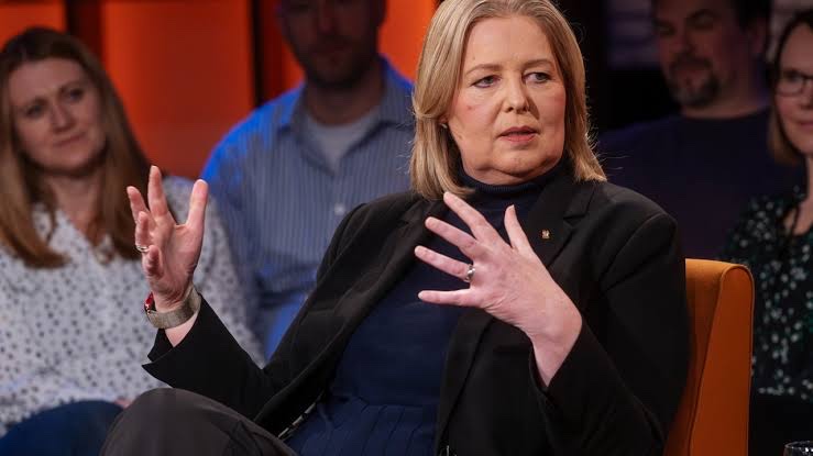 Bärbel Bas in a dark jacket gesturing with both hands while speaking in a television discussion studio, with audience members behind her