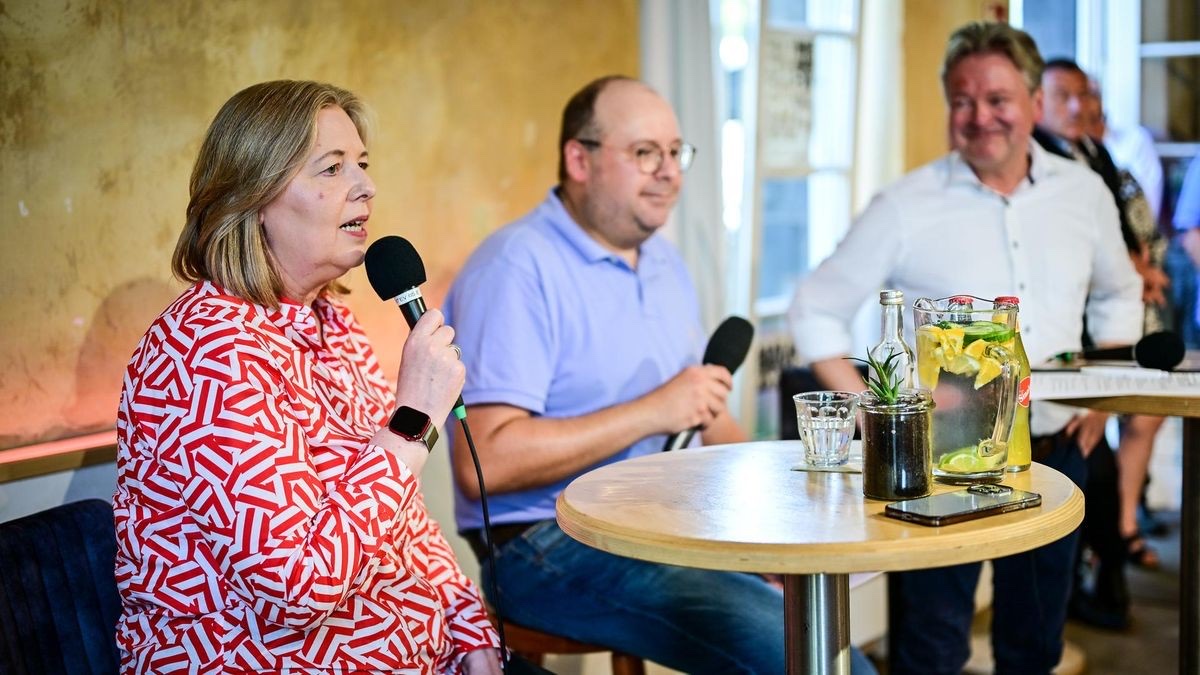 Bärbel Bas speaking into a microphone at a café table